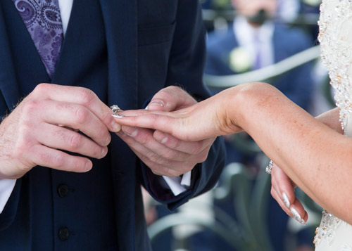 groom placing ring on brides finger