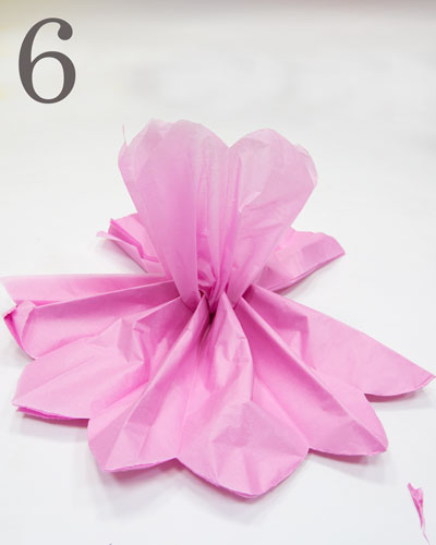 Pink tissue paper folded into a pompom shape at one side