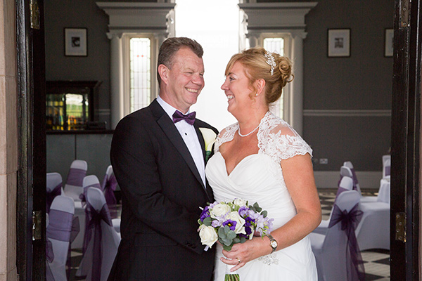 Bride and groom laughing in the doorway to the Old Weighing room at Doncaster Racecourse