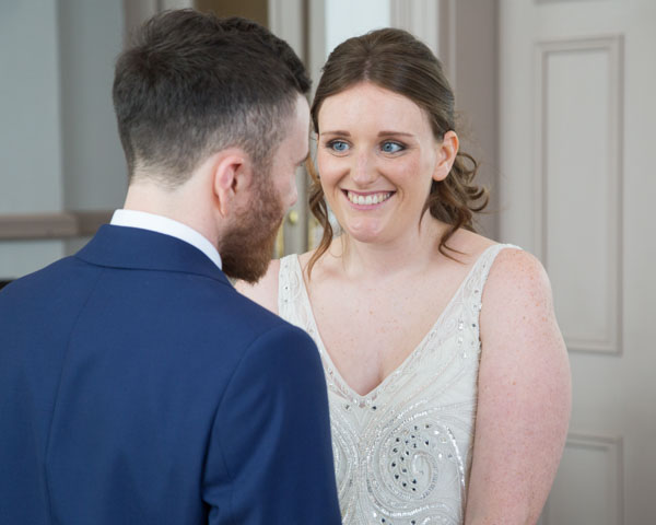 Bride smiling at groom during wedding ceremony in Leeds city hall