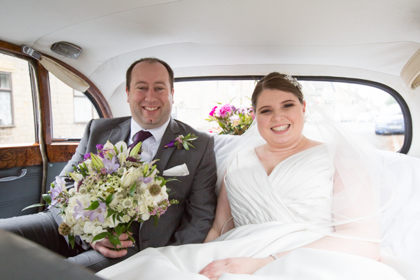 Groom with bride inside the wedding car