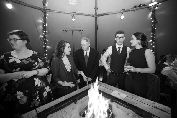 Guests around fire pit at Horsleygate Hall wedding