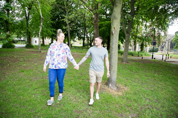 Couple holding hands and walking in the grounds of Watch church