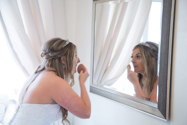 Bride fixing her makeup on the day of the wedding