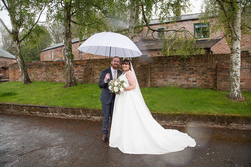 Bride and Groom with a white brolly at Elsecar Heritage Centre on their wedding day