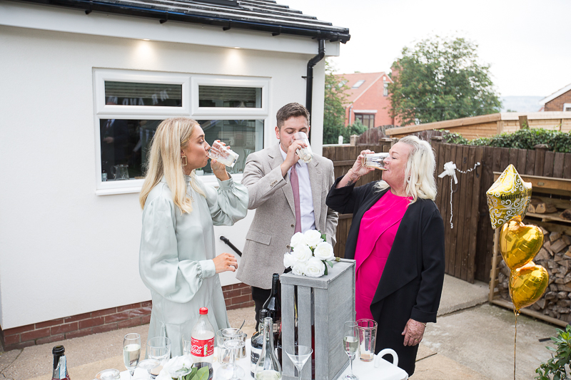Gusts laugh during back garden wedding reception for a covid wedding