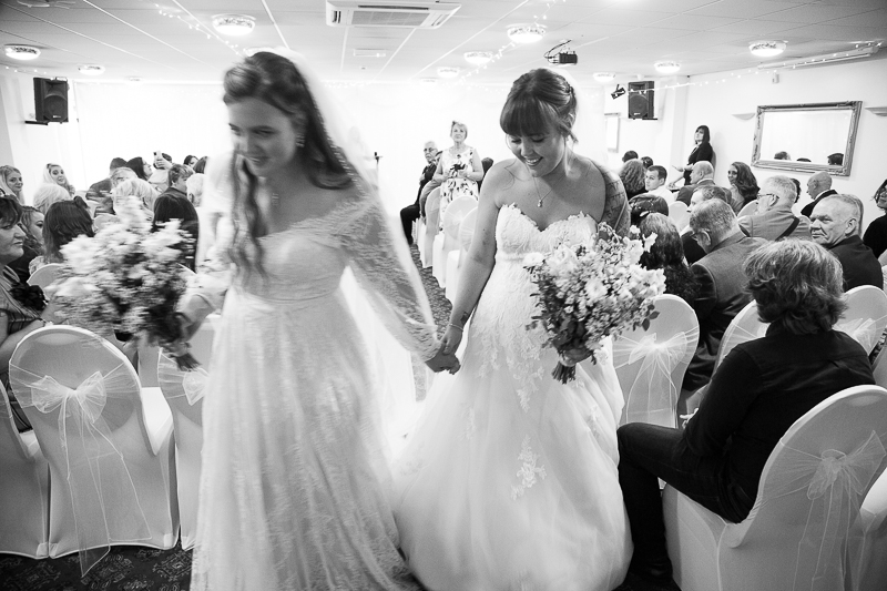 The brides leaving the wedding ceremony room at Shaw Lane Sports Club Barnsley
