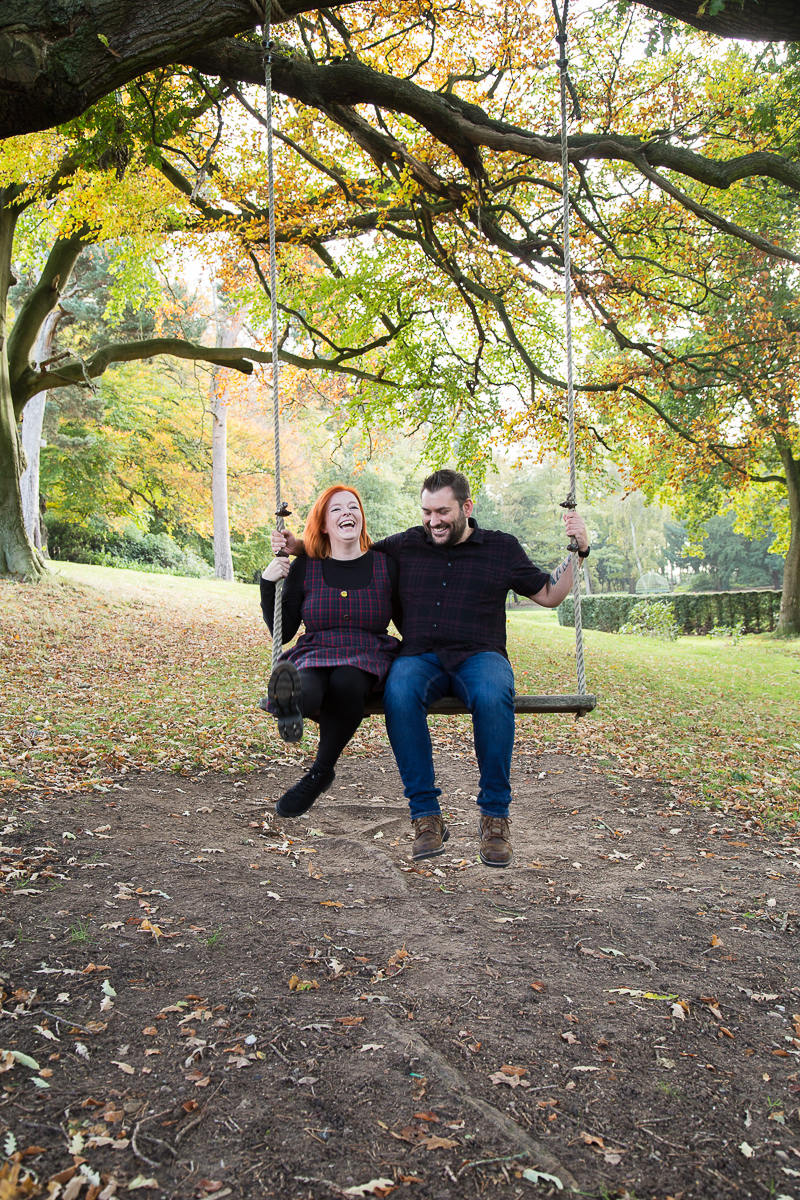 Couple laughing on a wooden swing in October wedding photographer south yorkshire