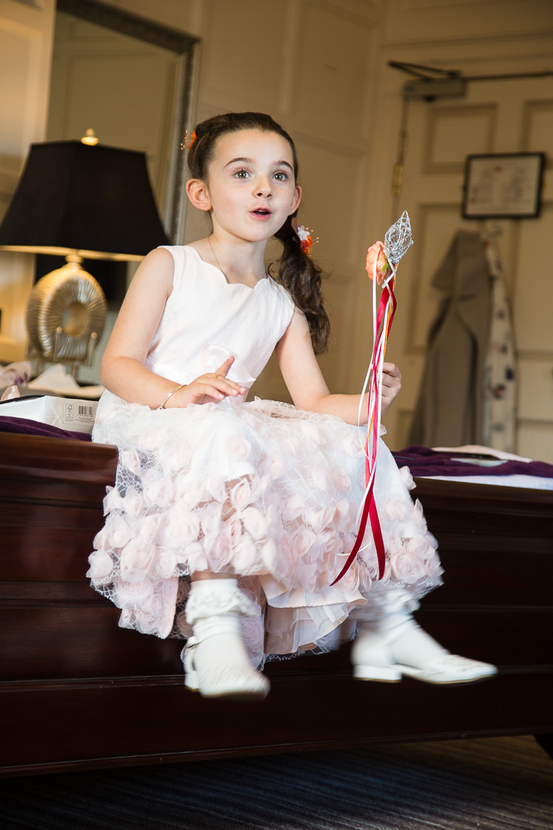 Flowergirl on the morning of the wedding sitting on the bed at Wortley Hall Hotel