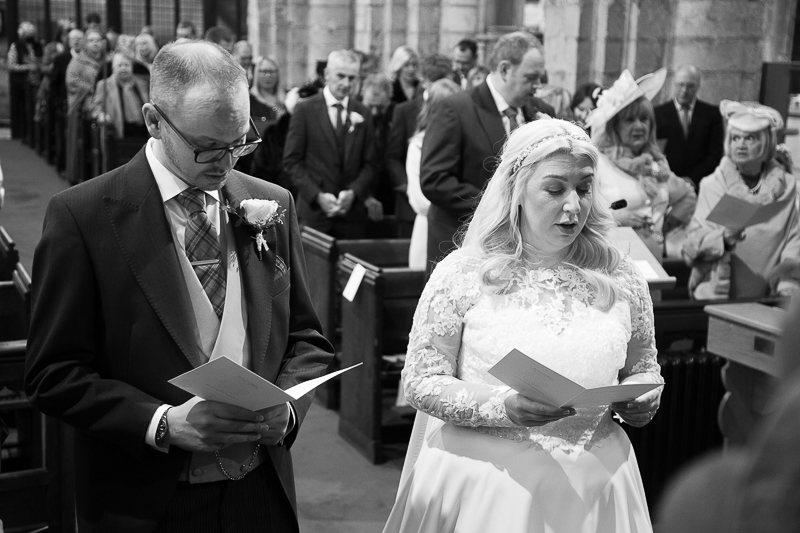 Bride and groom singing a hymn at St Mary & St Martin's Church Blyth