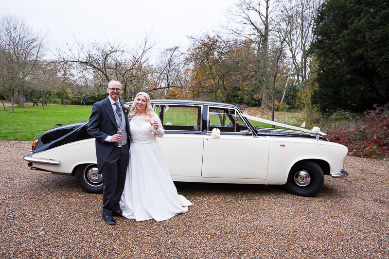 Bride and groom next to their wedding car at Hodsock Priory
