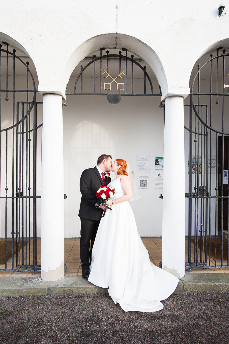 Newlyweds kiss in the archway of St Peter's church Warmsworth