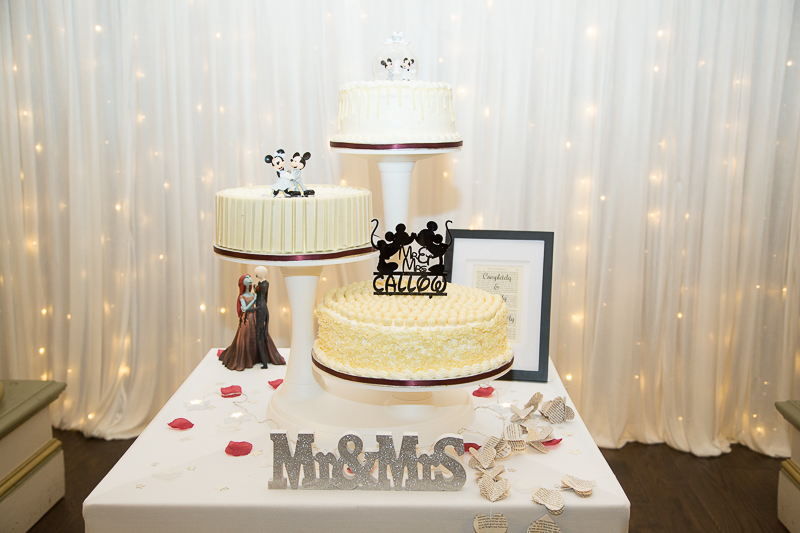 Three tier wedding cake on three cake stands with subtle disney theme