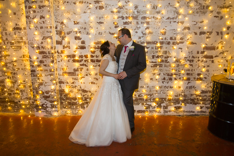 Couple against a fairy-light wall on their wedding day at The Hide Sheffield