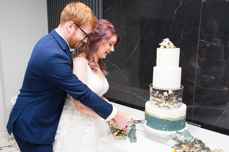Cutting the wedding cake in the QUBE at Burntwood Court Hotel