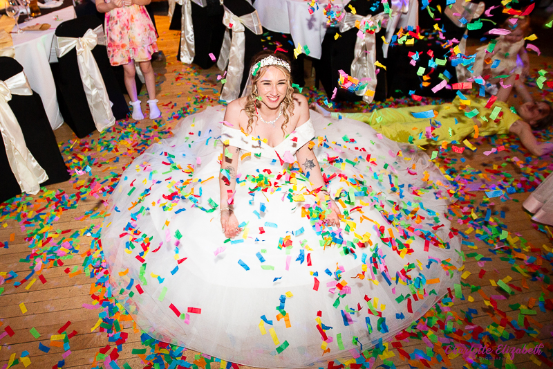 The bride sitting in confetti at The Earl of Doncaster wedding photographer
